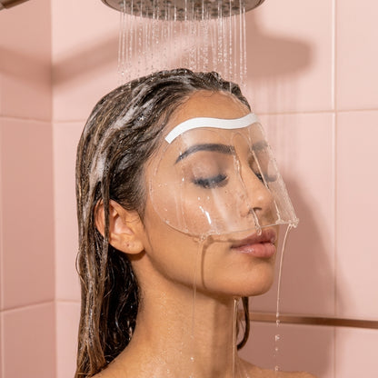 Donna sotto la doccia con lo scudo trasparente che protegge extension ciglia e sopracciglia dall'acqua